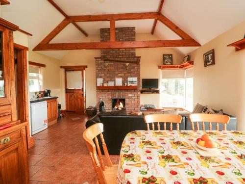 a kitchen and dining room with a table and a fireplace at The Granary in Castlerichard