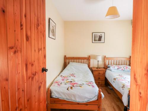 The Granary في Castlerichard: غرفة نوم بسريرين توأم وباب خشبي
