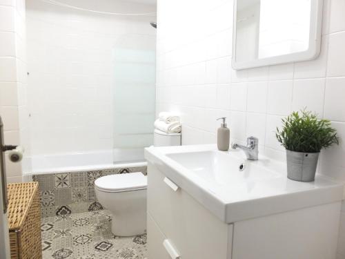 Baño blanco con lavabo y aseo en Apartamento La Zurri near Kursaal, en San Sebastián