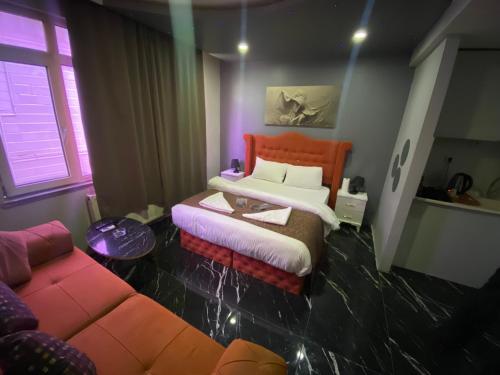 a bedroom with a bed and a couch in it at Bakırköy Macro Suite Otel in Istanbul