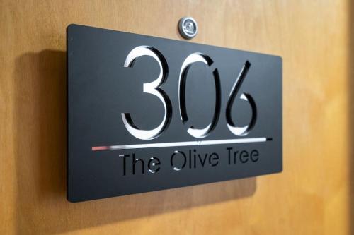 a sign for the alive tree on a wall at The Olive Tree with balcony and parking in Leicester