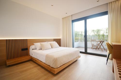 a bedroom with a bed and a balcony at VILLA LAREDO *** in Armentera