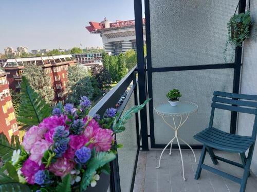 een balkon met een boeket bloemen en een stoel bij Milano SanSiroHouse Rho MI Fiera in Milaan