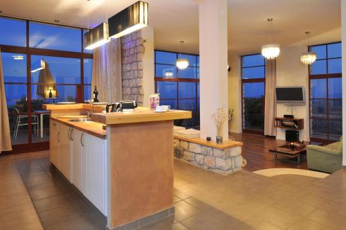 a kitchen with a sink and a living room with windows at Red and White אדום לבן in Amirim