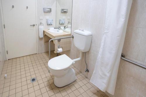 a bathroom with a toilet and a sink at Hawkesbury Race Club Motel in Windsor