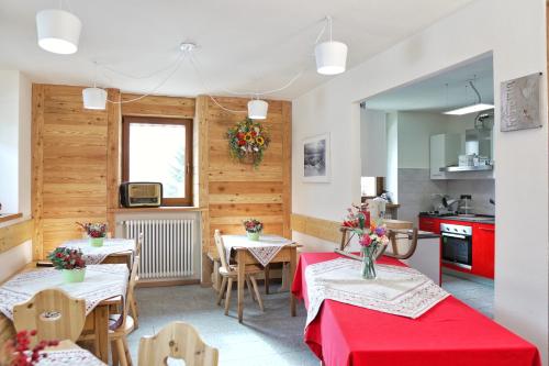 une salle à manger avec deux tables et une cuisine dans l'établissement Fohre1748, à Gressoney-La-Trinité