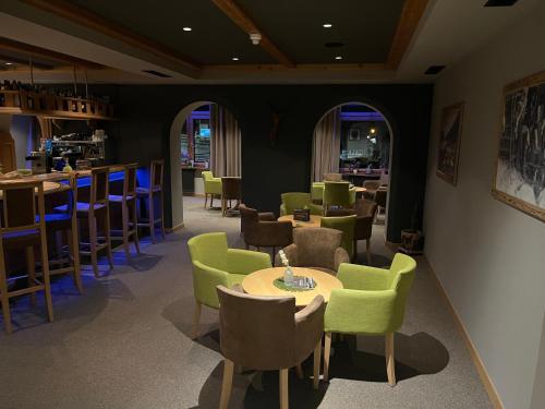 a restaurant with green chairs and tables and a bar at Vital Hotel Ortlerspitz in San Valentino alla Muta