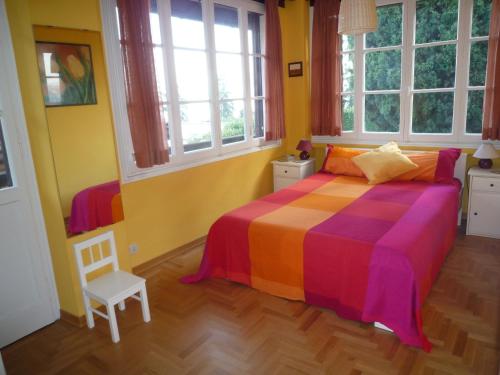 a bedroom with a colorful bed and two windows at Villanuvola in Meina