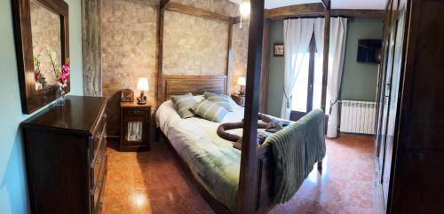 a bedroom with a four poster bed with a wooden frame at casa rural valderaduey 