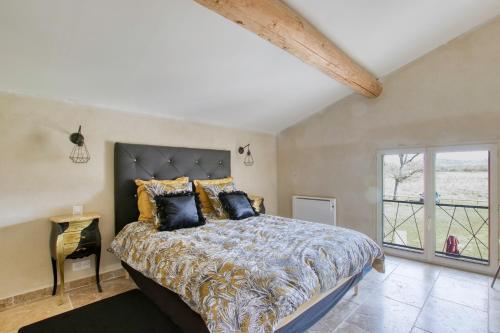 een slaapkamer met een groot bed en een raam bij Les Bellangers 1 - Piscine et Jacuzzi in Artigues
