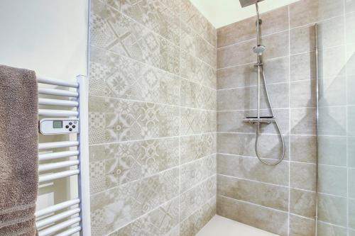 a bathroom with a shower with a shower head at Les Bellangers 1 - Piscine et Jacuzzi in Artigues