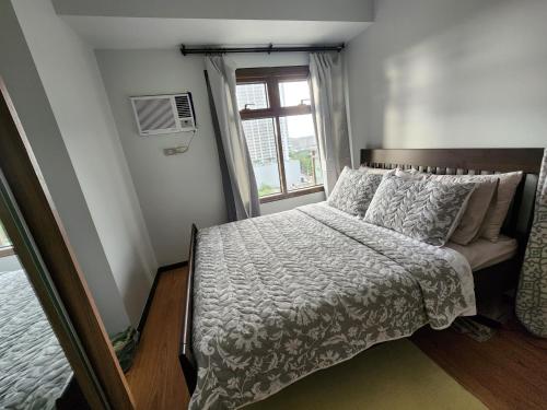 a small bedroom with a bed with a window at Abode at The Radiance Manila Bay in Manila