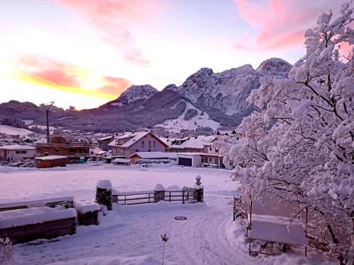 a village covered in snow with mountains in the background at Villa Edelweiss - 3 to 6 Guests - private use of indoor pool, sauna and garden terrace in Abtenau