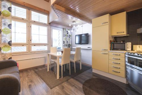 a kitchen and dining room with a table and chairs at Holiday Home Tintintaival in Tahkovuori