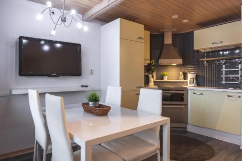 a kitchen and dining room with a table and chairs at Holiday Home Tintintaival in Tahkovuori