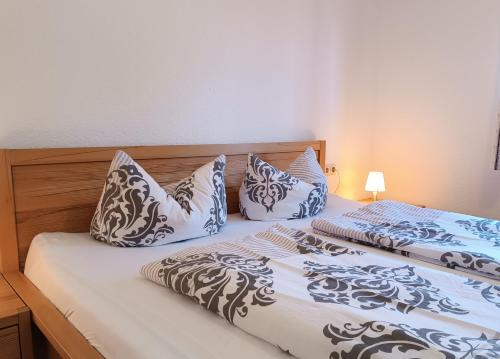 a bedroom with two beds with blue and white pillows at Akelei in Obermaiselstein