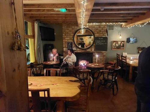 two men sitting in a restaurant with tables and chairs at Llandudno apartment, quirky pub with tropical beer garden in Llandudno
