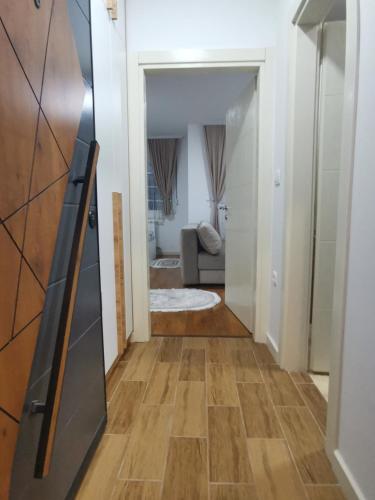 a hallway leading to a living room with wood floors at River Apartman in Bijelo Polje