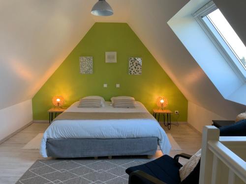 a bedroom with a large bed in a attic at Le Clos Marie in Sausseuzemare-en-Caux