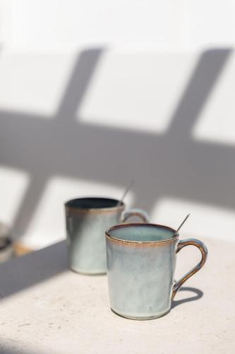 two metal coffee cups sitting on a counter at Elena Hotel Mykonos in Mýkonos City