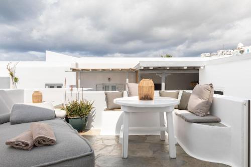 eine Terrasse mit Stühlen und einem Tisch auf dem Dach in der Unterkunft Elena Hotel Mykonos in Mykonos Stadt