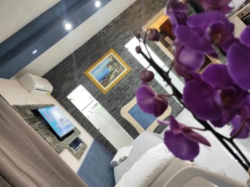 un vaso con fiori viola in soggiorno di PRESTIGE casa vacanze a Catanzaro
