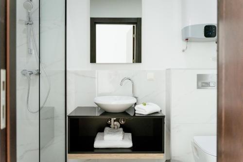 a white bathroom with a sink and a shower at Lamede in Wiener Neustadt