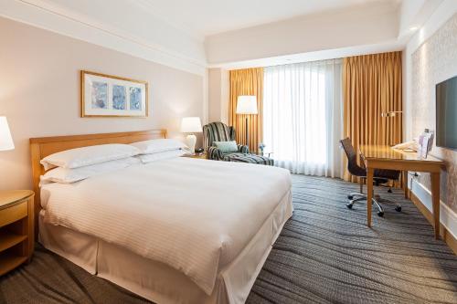 中和区にあるRSL Hotel Taipei Zhongheの大きなベッドとデスクが備わるホテルルームです。