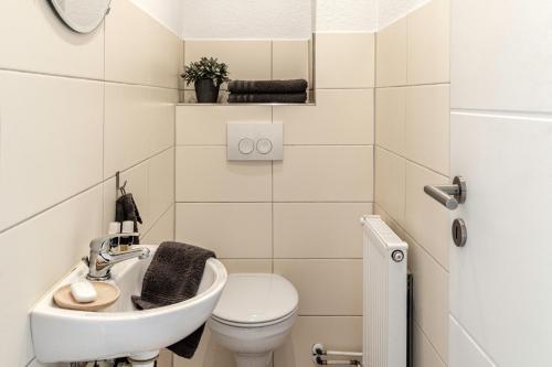 a small bathroom with a sink and a toilet at Haus KÖ 17 in Norderstedt