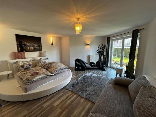 een slaapkamer met een bed en een woonkamer met een bank bij Villenartiges Haus nahe See in Grebin