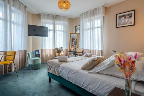 a bedroom with a large bed and a tv at Ama Hôtel in Biarritz
