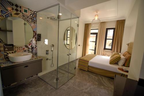 een badkamer met een bed, een wastafel en een douche bij Lovely Garden Flat with Patio near Hadrian's Gate in Antalya