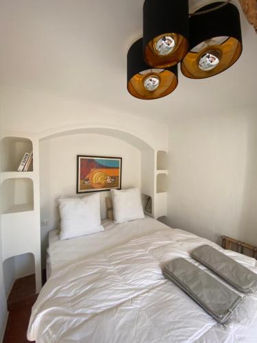 een slaapkamer met een wit bed en een plafond bij L'Appartement 31 Ramatuelle Vieux Village in Ramatuelle