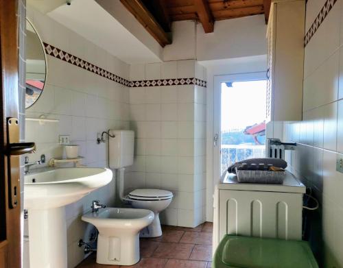 een badkamer met een wastafel, een toilet en een spiegel bij Ca del Vecchio in Ponte Nizza