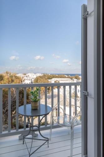 a table on a balcony with a view of the beach at Elena Hotel Mykonos in Mýkonos City