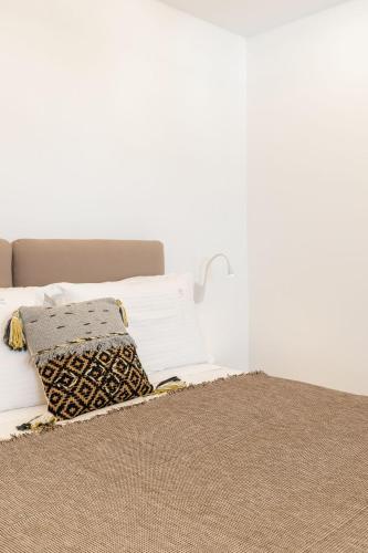 a bed with two pillows on top of it at Elena Hotel Mykonos in Mýkonos City