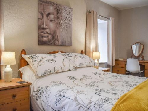 a bedroom with a bed and a painting on the wall at Ryecroft in Matlock