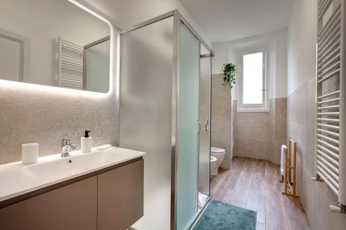 a bathroom with a sink and a shower and a toilet at Mamo Florence - Magenta Apartment in Florence