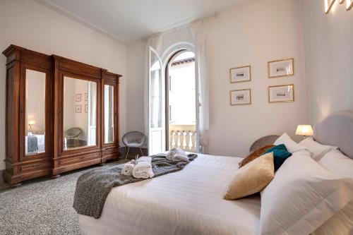 a bedroom with a large white bed and a window at Mamo Florence - Magenta Apartment in Florence