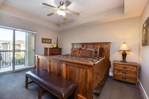 a bedroom with a wooden bed and a ceiling fan at W304-Mojave Skies Poolside 4 Bed Estancia Resort in St. George