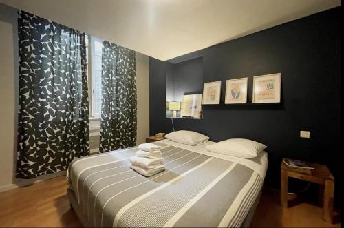 1 dormitorio con 1 cama con toallas en Matisse 50 - Appartement Avignon centre, en Aviñón