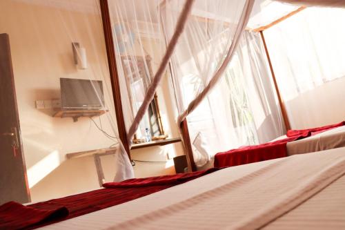Darajani Hotel في مومباسا: غرفة نوم بسريرين ونافذة