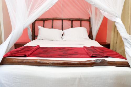 a bedroom with a bed with a red blanket at Darajani Hotel in Mombasa