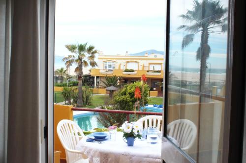 a table with white chairs and a view of a house at Apartamento Cosmos Sur in Tarifa