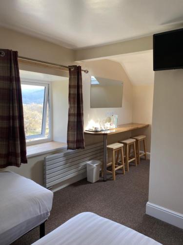 a hotel room with a desk and a window at Church Hill House in Betws-y-coed