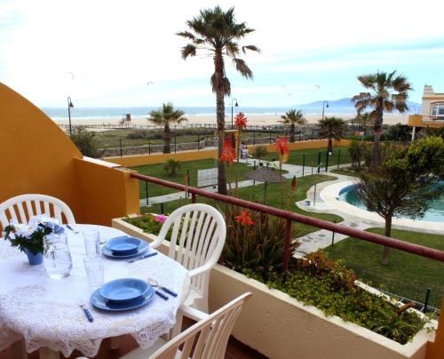 a table and chairs on a balcony with a view of the beach at Apartamento Cosmos Sur in Tarifa