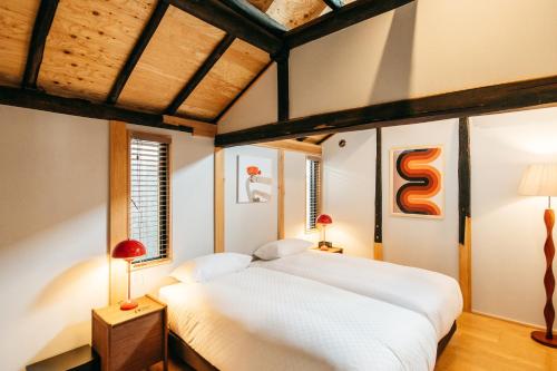 a bedroom with a large white bed and two lamps at Yado Charinko in Gose