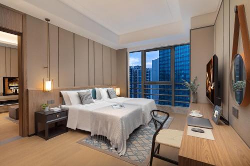 a hotel room with a bed and a large window at Ascott M-City Foshan in Foshan