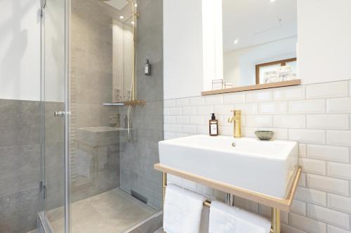 La salle de bains blanche est pourvue d'un lavabo et d'une douche. dans l'établissement Schattenhofer Braugasthof, à Beilngries