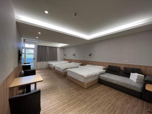 ChaozhouにあるFive Rabbitsのベッド2台とソファが備わる広い客室です。